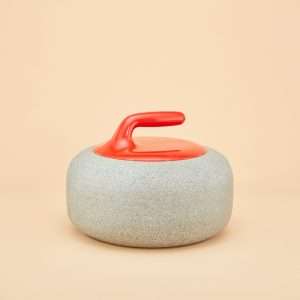 An urn that looks like a curling stone. A red handle and stone base