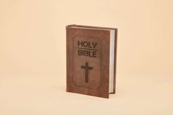 An urn that looks like a bible, brown leather with a cross embossed in the leather