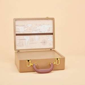 An urn that looks like a tan leather suitcase with gold latches and a brown handle. It is it is open and is lined with a map of the world