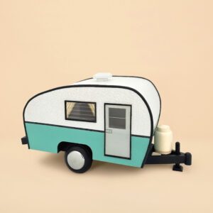 An urn that looks like a white and mint blue trailer camper. It has wheels and a propane tank, door and windows with curtains