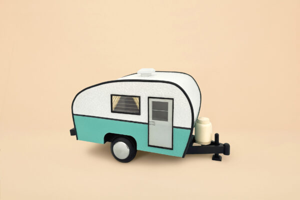 An urn that looks like a white and mint blue trailer camper. It has wheels and a propane tank, door and windows with curtains