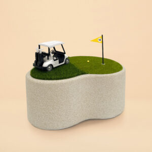 An urn that looks like a golf cart on the putting green. There is a yellow flag and golf hole