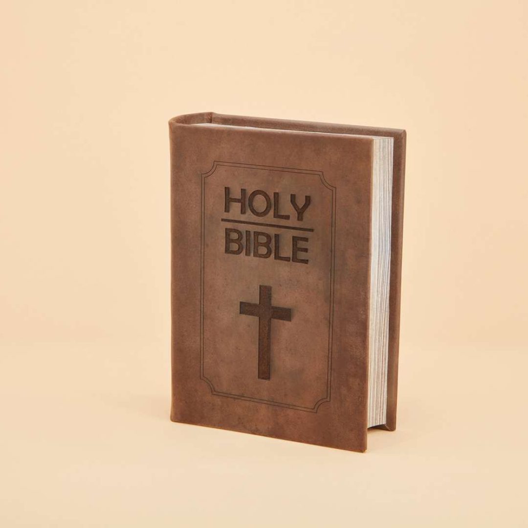 An urn that looks like a bible, brown leather with a cross embossed in the leather